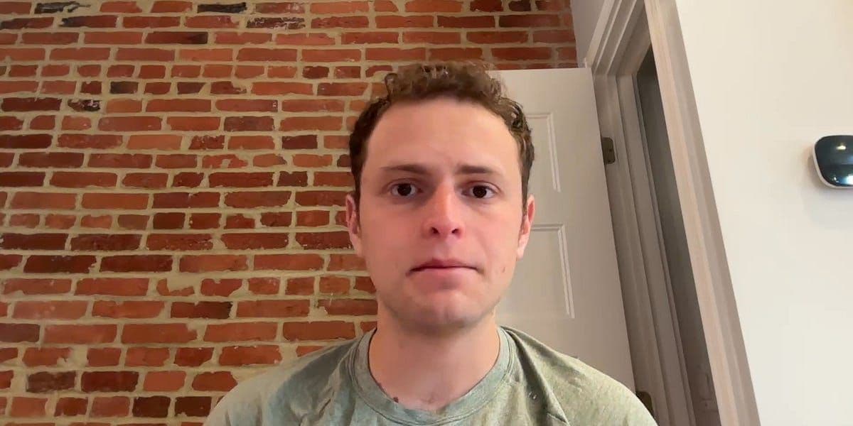 Protesters gathering with signs at a demonstration against Trump administration policies